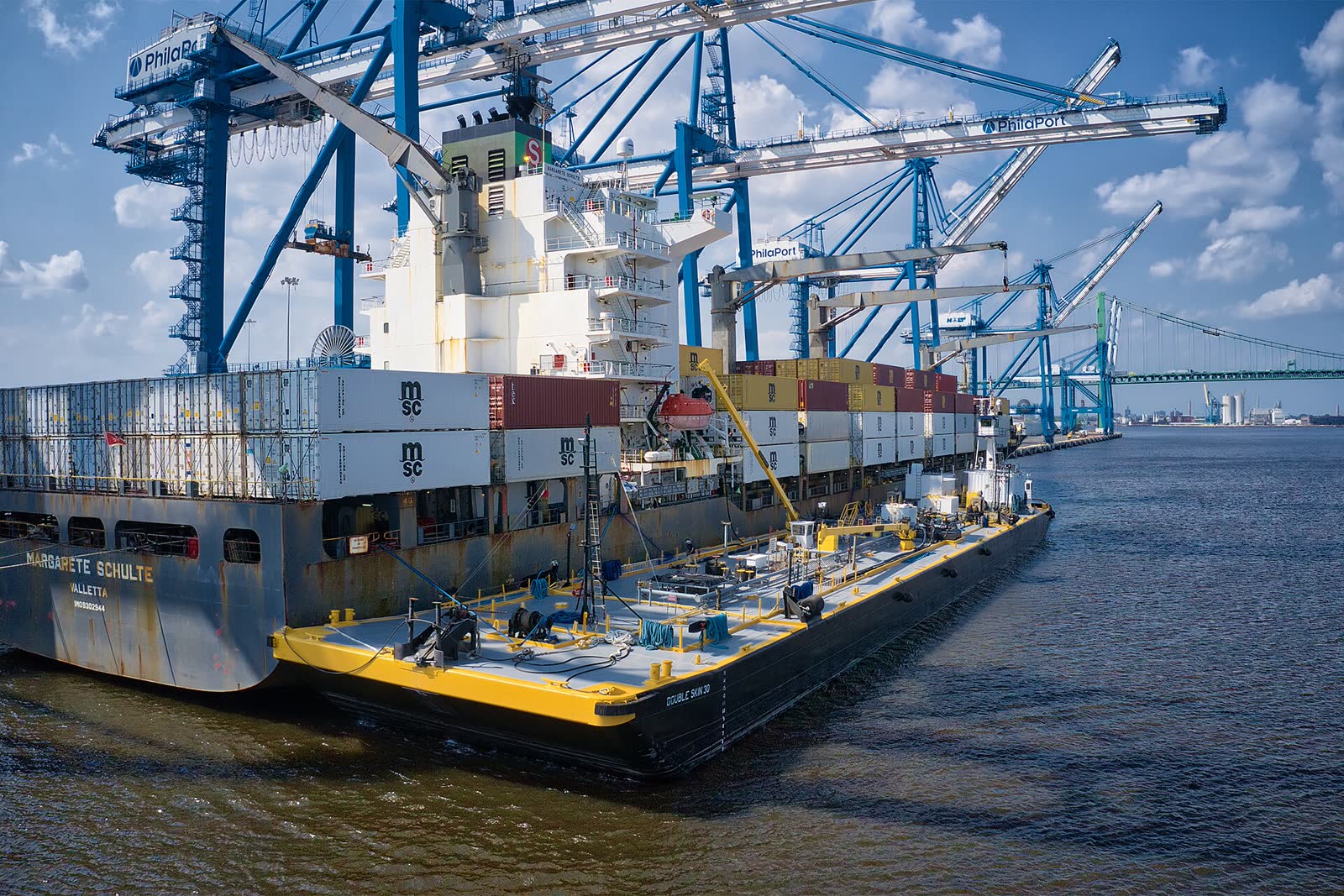 Bunker barge made fast alongside a container ship at a terminal