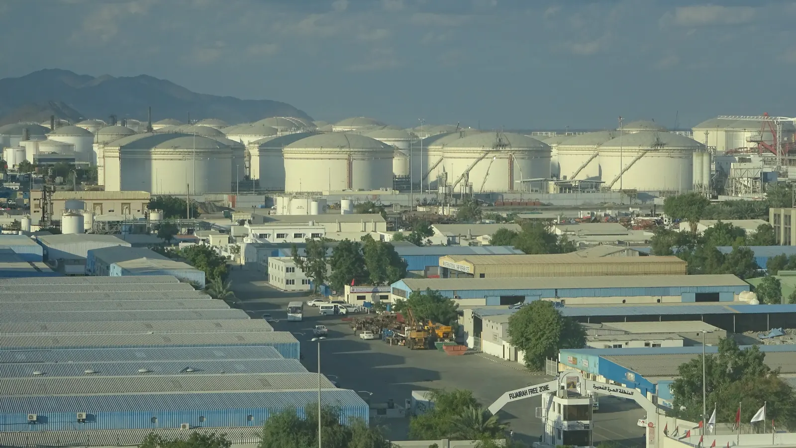 Oil storage tanks at the Port of Fujairah, with the Hajar Mountains behind